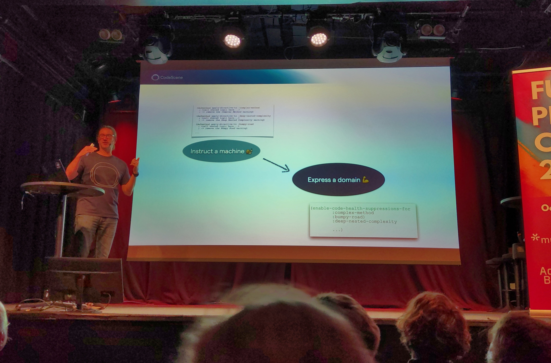Adam presents a slide showing a diagram of moving from instructing a machine to expressing a domain