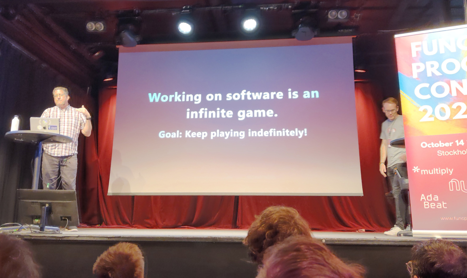 Christoph presents a slide labelled "Working on software is indefinite, therefore an infinite game"