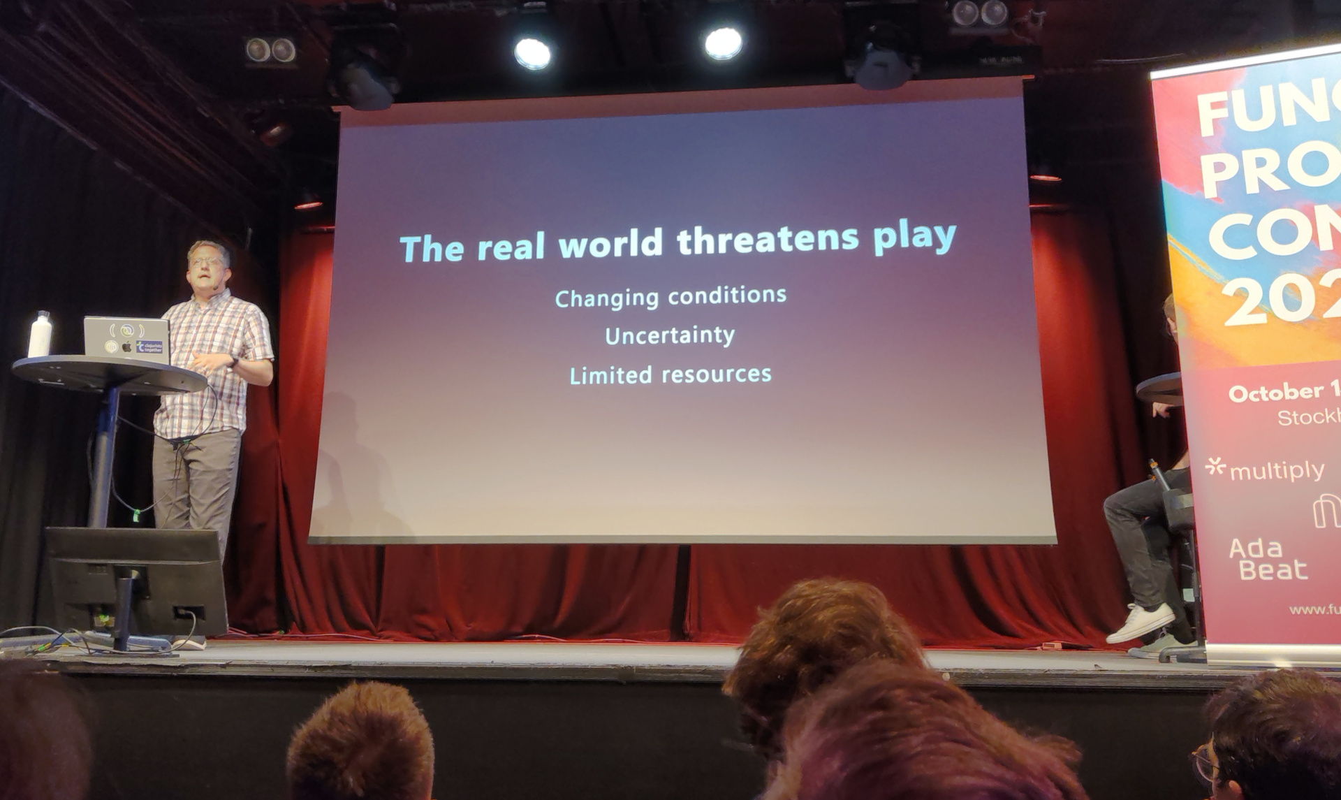 Christoph presents a slide labelled "The real world threatens play"